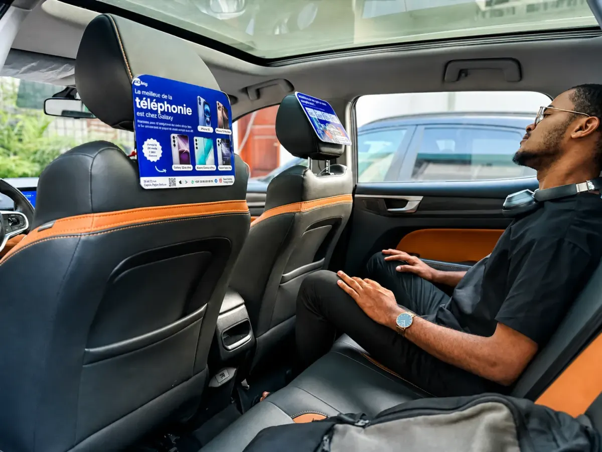Écran publicitaire GoCab Boost fixé sur l'appui-tête d'un VTC, face à un passager